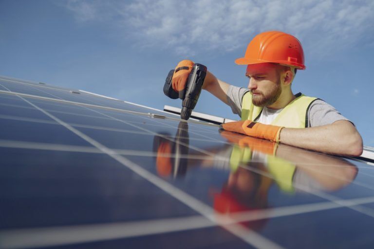 Solar panel installer at work, showcasing solar power on roof, solar energy cost, and best solar energy solutions.